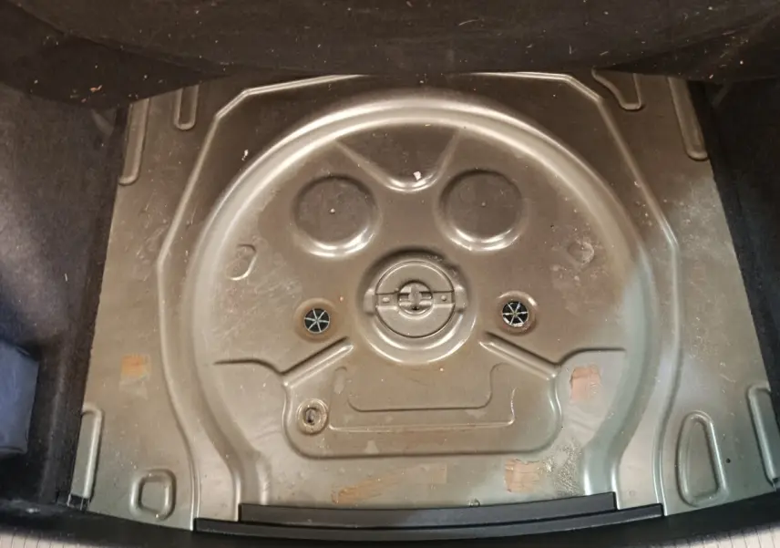 Coffre ouvert montrant le logement noir du pneu de secours du Volkswagen Tiguan 2.0 TDI 150 DSG7 Elegance.