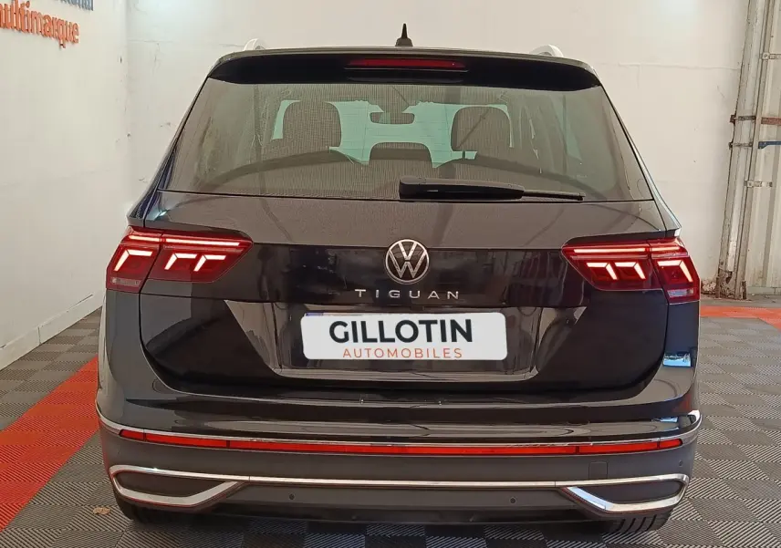 Vue arrière d'un Volkswagen Tiguan noir 2022 avec feux LED allumés dans un garage.