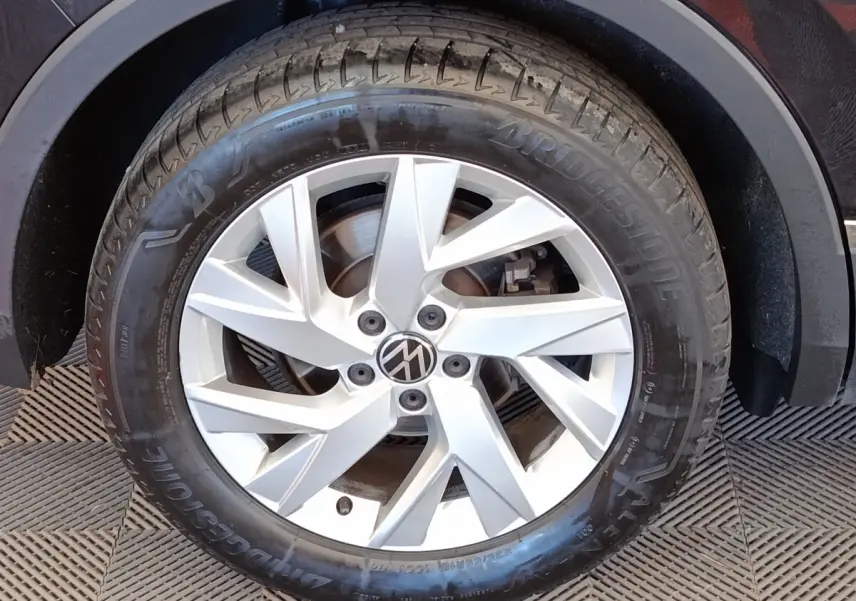 Gros plan sur la roue avant droite d’un Volkswagen Tiguan noir, avec jante alliage argentée et pneu Bridgestone.