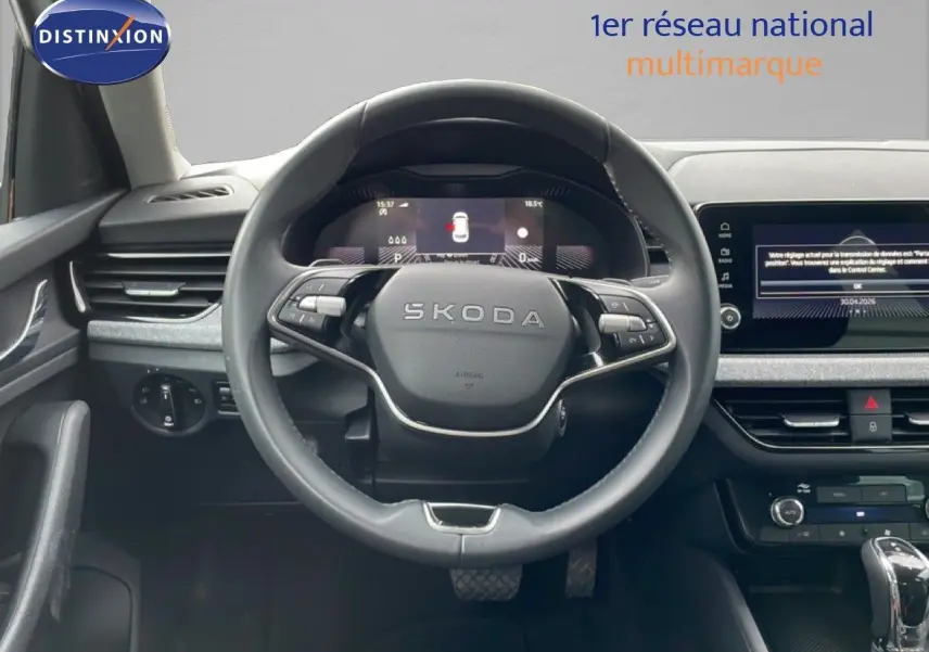 Vue intérieure centrée sur le volant noir du Skoda Kamiq 2025 avec tableau de bord digital et écran tactile.