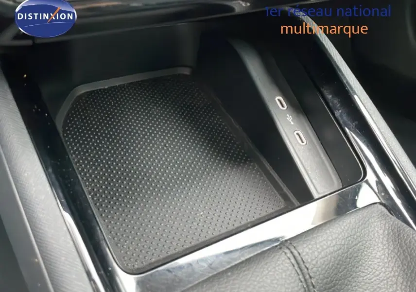 Gros plan sur la console centrale noire du Skoda Kamiq 2025, avec zone de recharge sans fil et ports USB visibles.