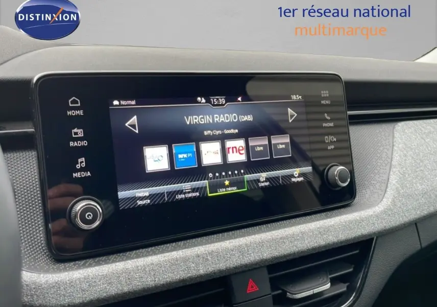 Vue rapprochée de l’écran tactile central du Skoda Kamiq 2025, affichant la radio Virgin Radio sur un tableau de bord gris texturé.