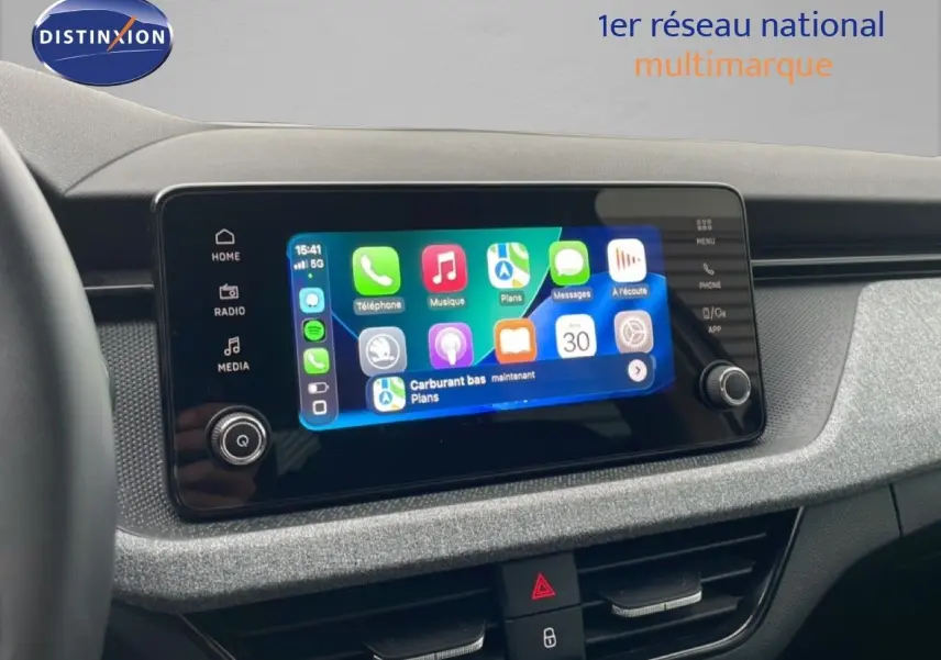 Vue intérieure du tableau de bord du Skoda Kamiq blanc glacier 2025, avec écran tactile multimédia allumé.