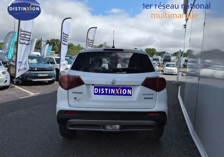 Vue arrière d'un Suzuki Vitara Galactic Gray métallisé, avec feux arrière LED et hayon fermé sur parking.