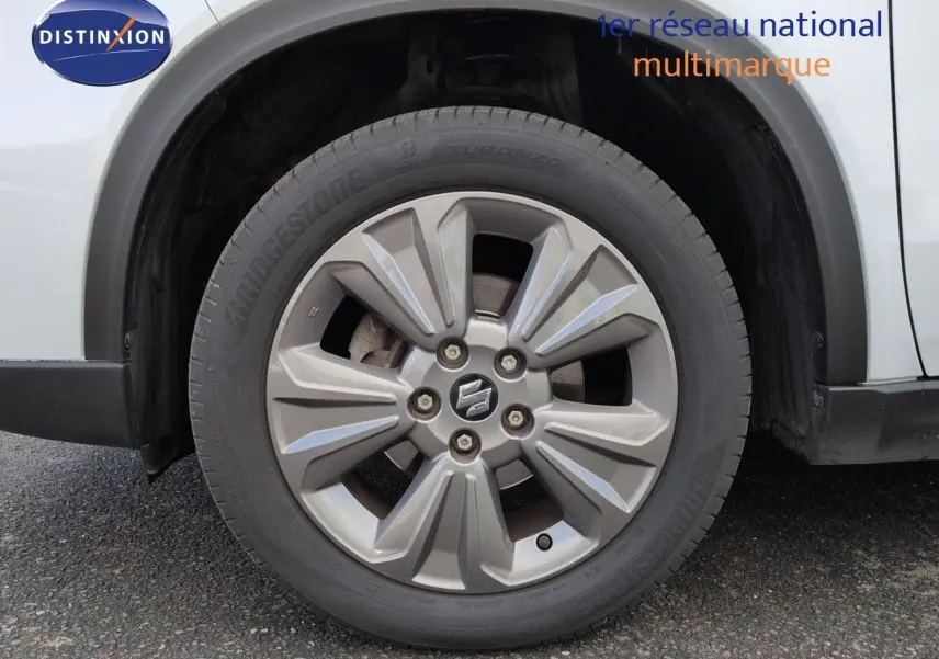 Gros plan sur la roue avant gauche du Suzuki Vitara 1.4 Boosterjet Hybrid 2021 en Galactic Gray métallisé.
