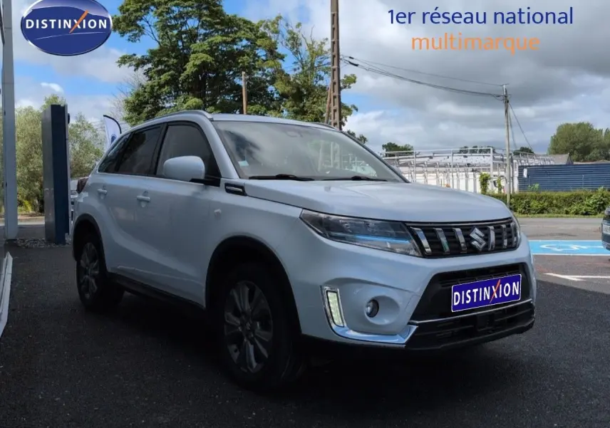 Suzuki Vitara 1.4 Boosterjet Hybrid gris Galactic, vue 3/4 avant droit avec calandre chromée et feux LED.