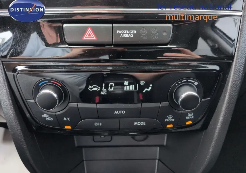 Vue rapprochée de la console centrale noire du Suzuki Vitara 1.4 Boosterjet Hybrid avec commandes de climatisation digitales.