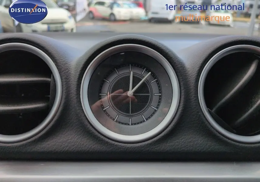 Gros plan sur l'horloge centrale du tableau de bord du Suzuki Vitara 1.4 Boosterjet Hybrid gris métallisé.