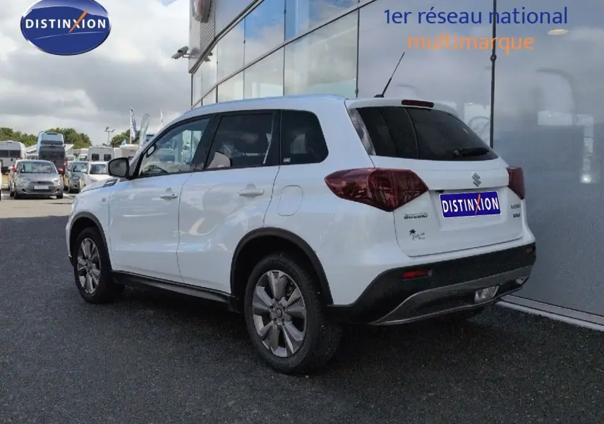 Suzuki Vitara blanc vue 3/4 arrière droit, avec vitres arrière surteintées et jantes alliage.