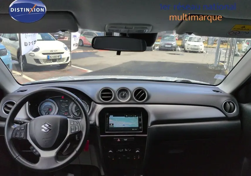 Vue intérieure avant du Suzuki Vitara 1.4 Boosterjet Hybrid 2021, tableau de bord noir avec écran tactile et volant multifonction.