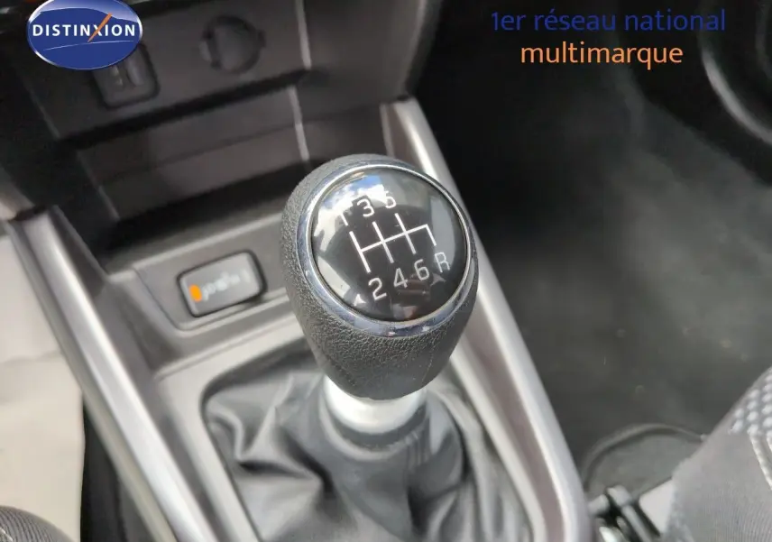 Gros plan sur le levier de vitesses manuel noir et chrome dans l’habitacle du Suzuki Vitara Galactic Gray.