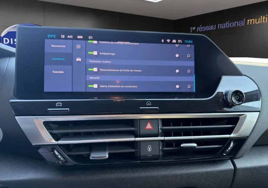 Vue rapprochée de l’écran tactile central et des commandes de climatisation du tableau de bord du Citroën C4 gris foncé 2023.