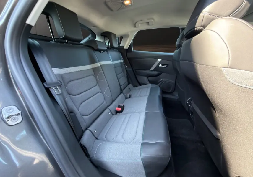 Vue intérieure côté gauche des sièges arrière gris clair et cuir noir d'une Citroën C4 gris foncé 2023.