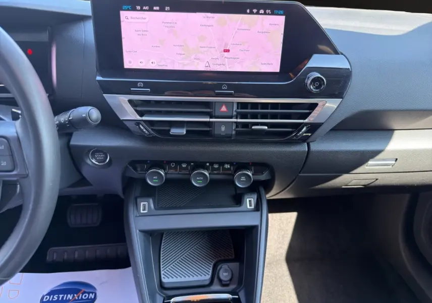 Vue intérieure centrée sur la console centrale et l'écran tactile de navigation du Citroën C4 2023 gris foncé.