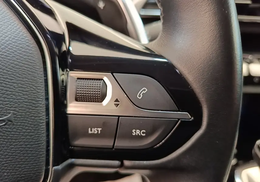Gros plan sur les commandes multifonctions du volant cuir noir du Peugeot 3008 PureTech 130 S&S EAT8 Allure.