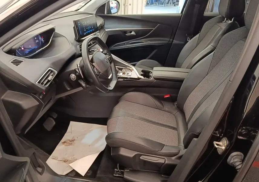 Vue intérieure côté conducteur du Peugeot 3008 noir, mettant en valeur le volant cuir multifonctions et l'écran tactile central.