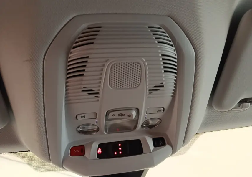 Vue en gros plan du plafonnier intérieur gris clair du Peugeot 3008 noir, avec boutons SOS et éclairage.