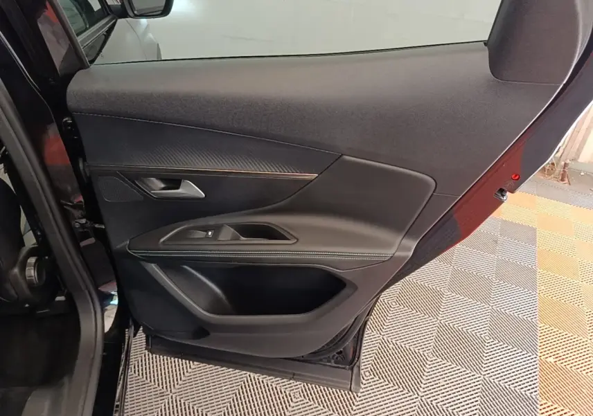 Vue intérieure de la porte arrière gauche noire du Peugeot 3008, avec garniture en tissu et insert décoratif.