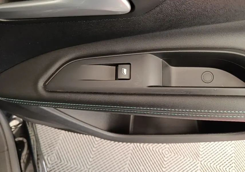 Gros plan sur la poignée intérieure et le bouton de lève-vitre côté conducteur du Peugeot 3008 noir 2022.