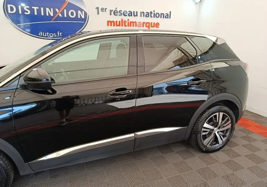 Profil côté gauche du Peugeot 3008 noir avec jantes alliage et détails chromés sous les portes, en intérieur showroom.