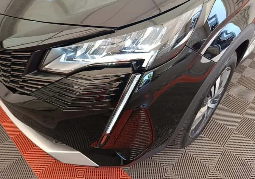 Gros plan sur l’avant droit noir brillant du Peugeot 3008 2022, mettant en valeur le phare LED et la calandre moderne.