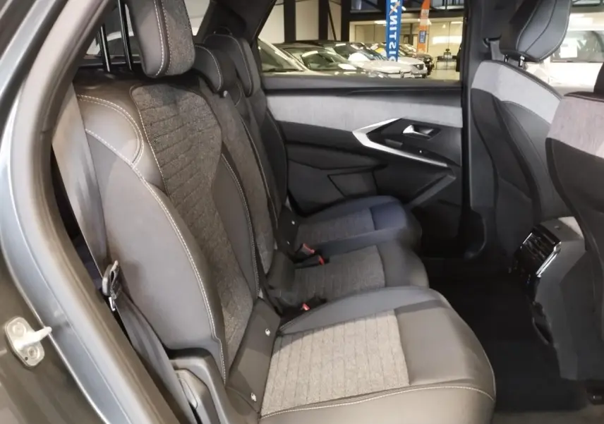 Vue côté gauche de la banquette arrière tissu gris et cuir noir du Peugeot 5008 gris titanium 2025 hybride.
