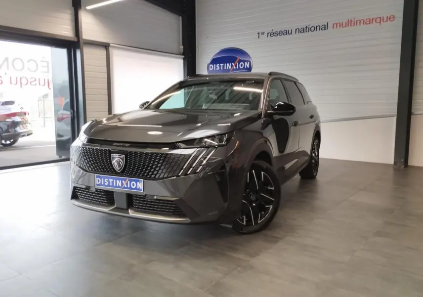 Peugeot 5008 gris titanium en 3/4 avant droit, avec calandre noire et jantes alliage noires diamantées.