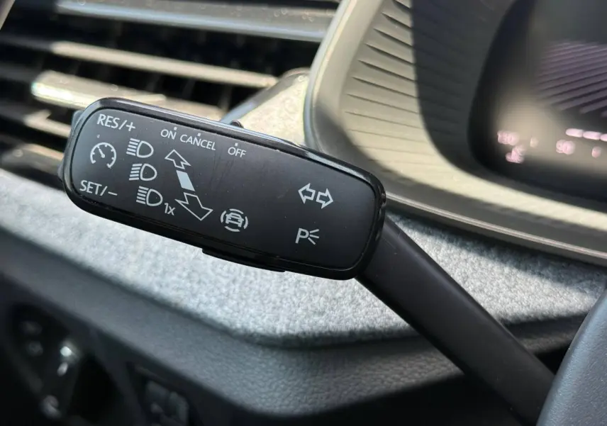Gros plan sur la commande de régulateur de vitesse et clignotants du Skoda Kamiq 2025, intérieur noir.