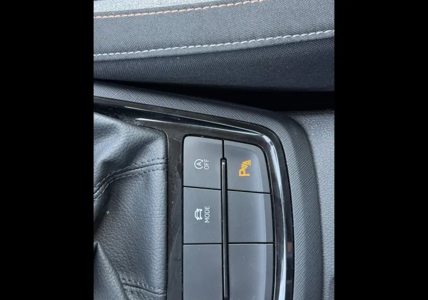 Gros plan sur les boutons de commande du frein de stationnement et mode conduite du Skoda Kamiq 2025, intérieur noir.