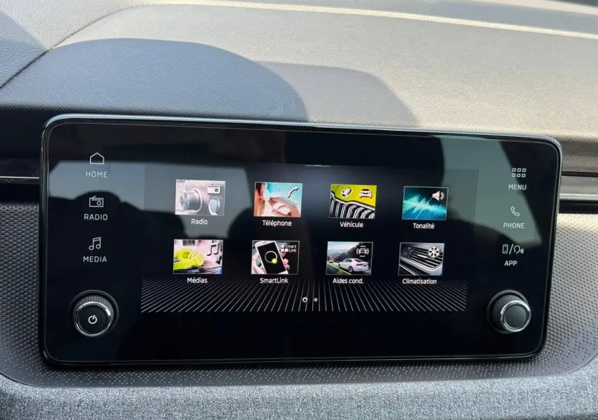 Écran tactile central du Skoda Kamiq 2025 affichant les menus radio, téléphone, véhicule et climatisation, avec finition intérieure grise.