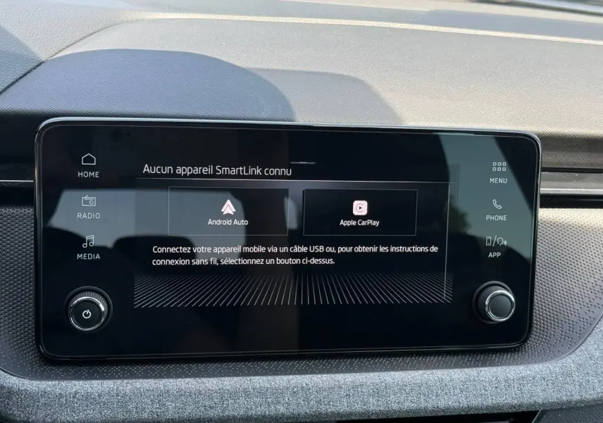 Écran tactile central du Skoda Kamiq 2025 affichant les options Android Auto et Apple CarPlay, entouré d'un tableau de bord gris.