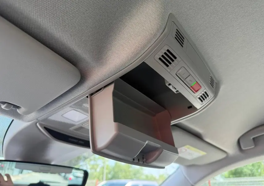Boîte à lunettes ouverte vue de l'intérieur du toit d'un Skoda Kamiq 2025, avec plafonnier et commandes intégrées.