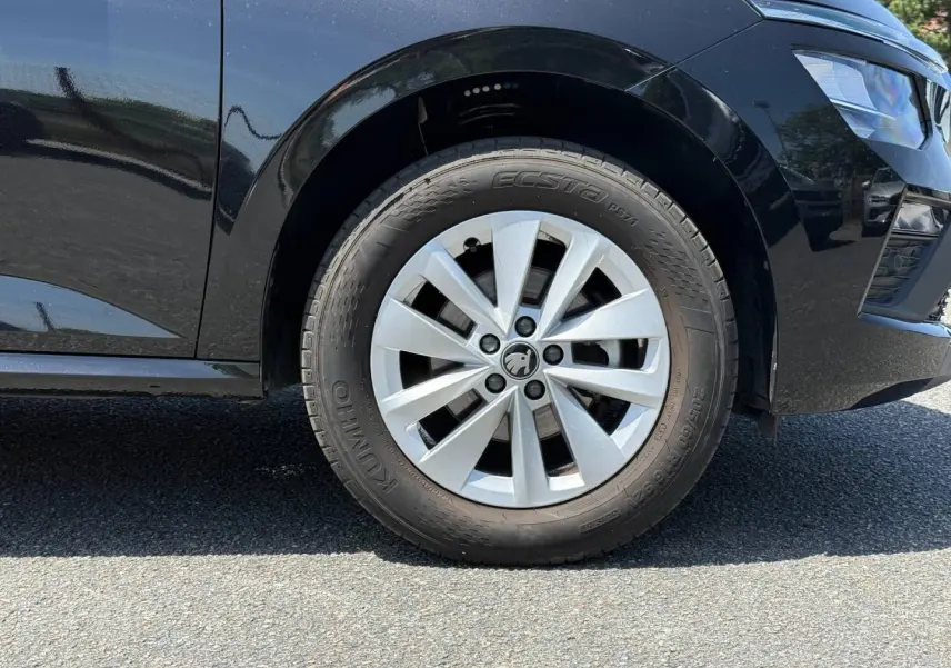 Gros plan sur la roue avant droite d’un Skoda Kamiq noir Magic nacré, mettant en valeur la jante et le pneu.