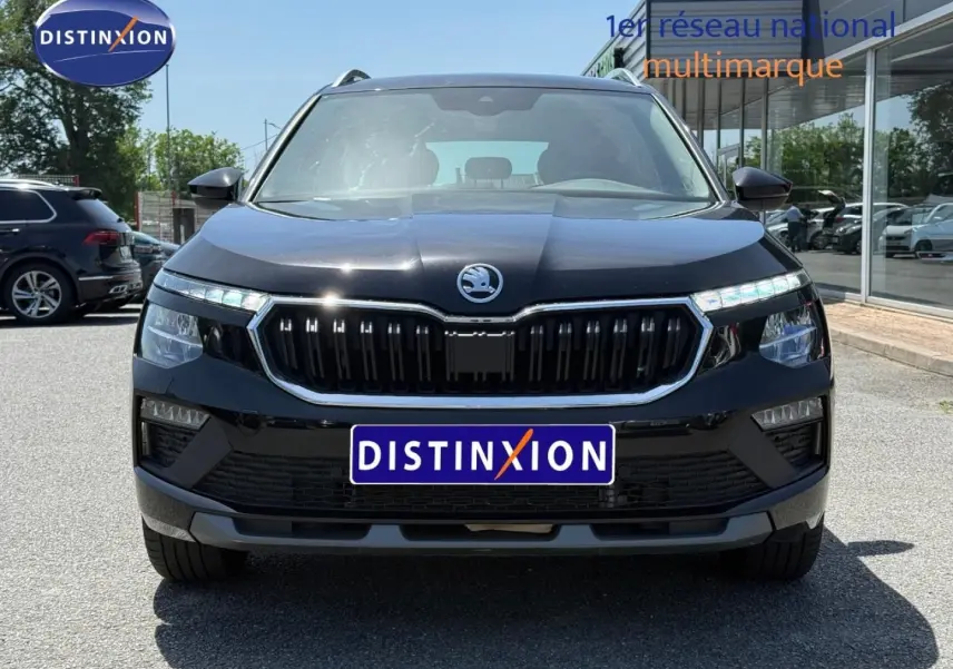 Vue frontale d'un Skoda Kamiq 2025 noir Magic nacré avec calandre chromée et phares LED allumés.