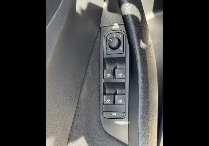 Vue rapprochée des commandes de lève-vitres et réglage des rétroviseurs côté conducteur du Skoda Kamiq 2025 noir Magic nacré.