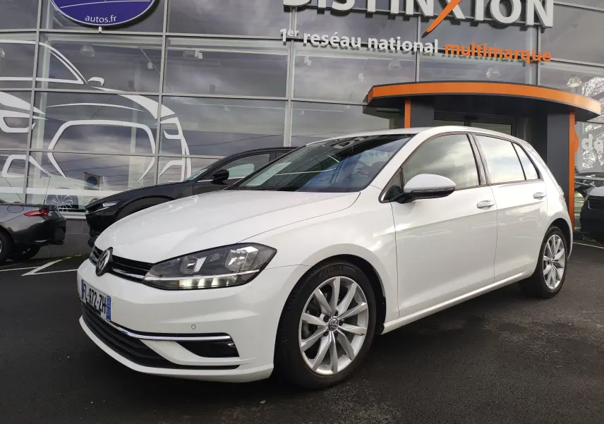 Volkswagen Golf 1.5 TSI EVO blanche vue 3/4 avant droit, avec jantes alliage et feux LED allumés.