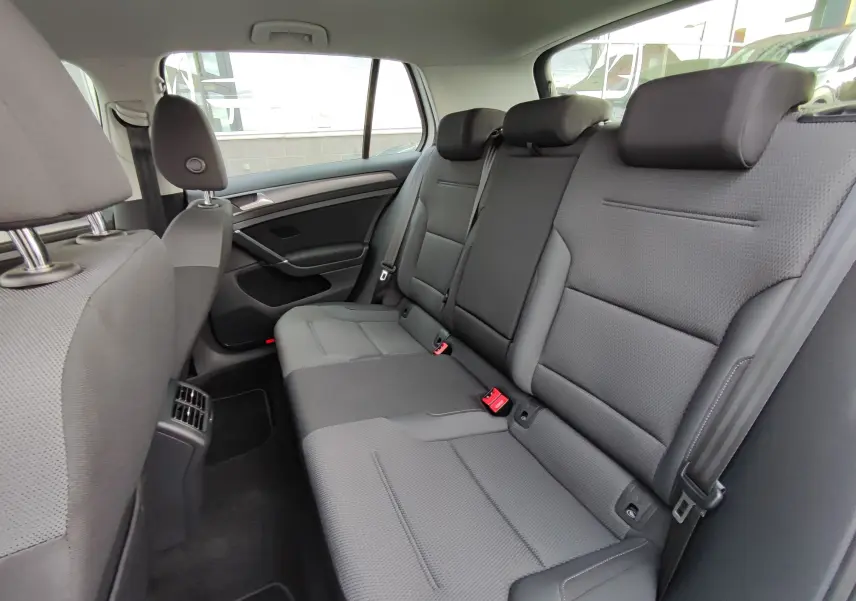 Vue intérieure côté droit des sièges arrière gris foncé d'une Volkswagen Golf 1.5 TSI EVO 2019, avec appuie-têtes et ceintures visibles.