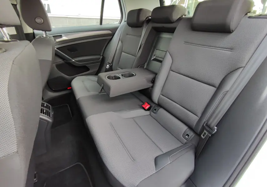 Vue intérieure côté droit des sièges arrière gris foncé de la Volkswagen Golf 1.5 TSI EVO 2019 avec accoudoir central relevé.