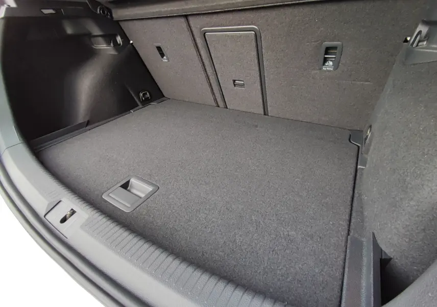 Coffre spacieux de Volkswagen Golf 1.5 TSI EVO blanc, vue intérieure en plongée montrant le plancher et les fixations.