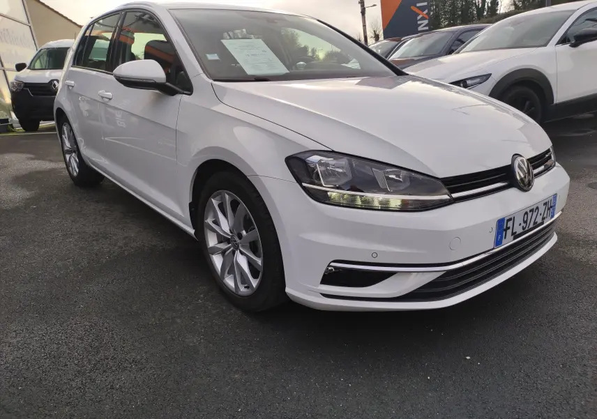 Volkswagen Golf 1.5 TSI blanc vue 3/4 avant droit, avec phares LED et jantes alliage visibles.