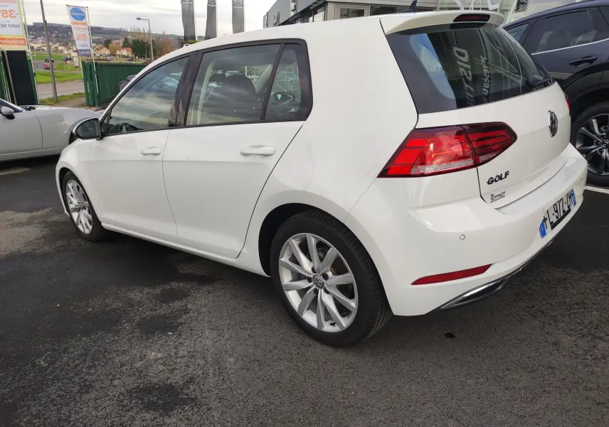Vue 3/4 arrière droite d'une Volkswagen Golf blanche 1.5 TSI EVO 2019 avec jantes alliage et feux arrière LED.