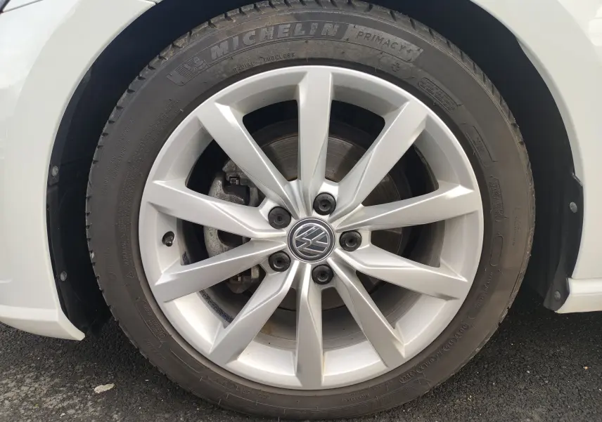 Gros plan sur la roue avant droite d’une Volkswagen Golf blanche 1.5 TSI EVO 2019 avec jante alliage et pneu Michelin.