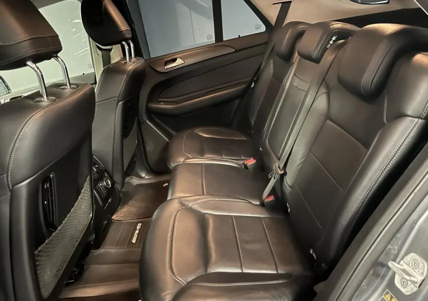 Vue intérieure côté droit des sièges arrière en cuir noir du Mercedes GLE 400 Fascination 2018 avec tapis AMG.