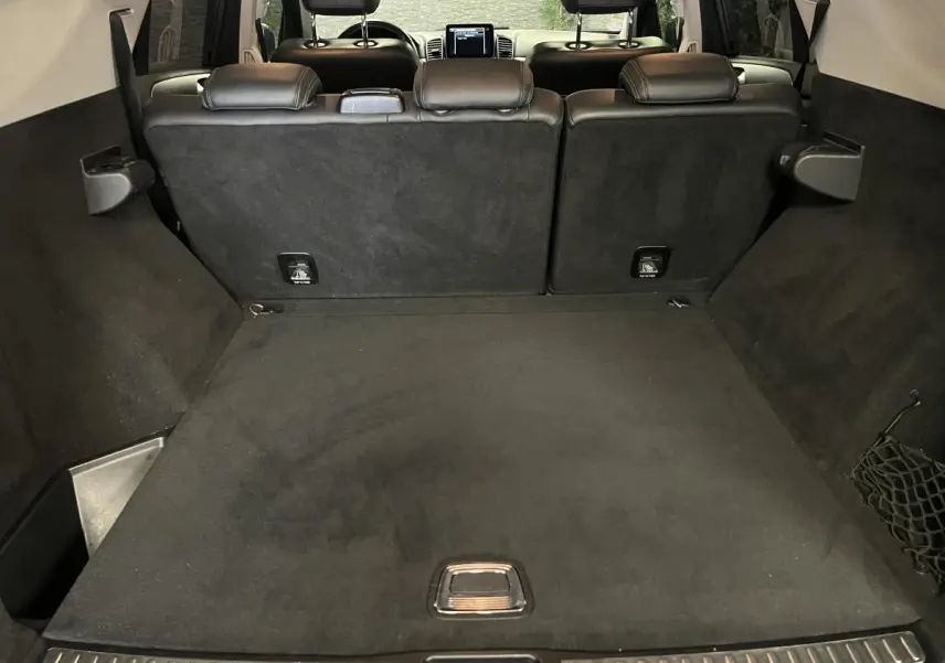 Coffre spacieux du Mercedes GLE 400 gris, vue arrière avec banquette arrière en cuir noir et tablette centrale visible.