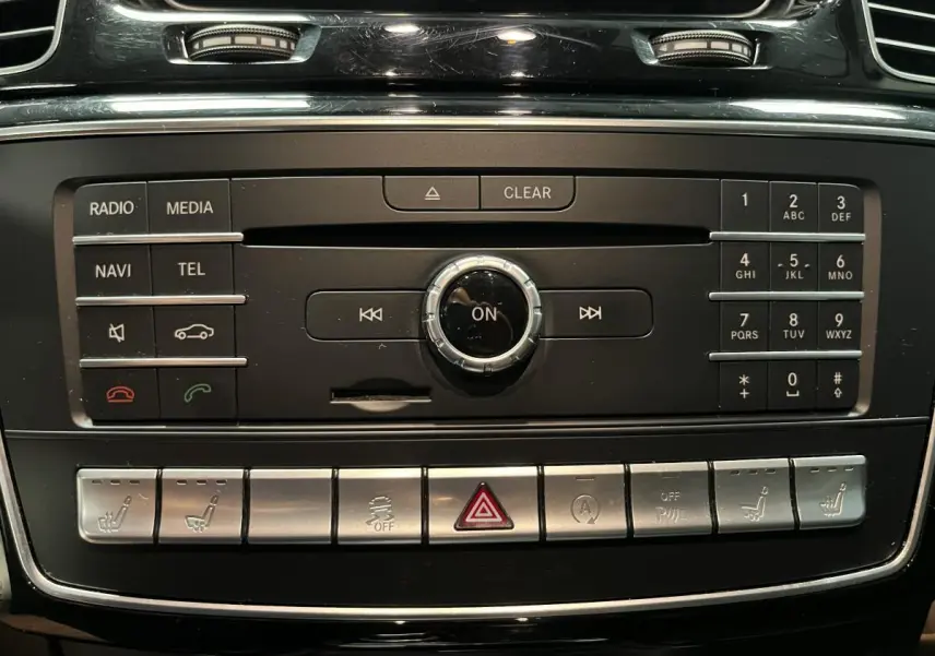 Panneau de commande central noir et argenté du Mercedes GLE 400 Fascination 2018 avec boutons multifonctions et commandes de sièges chauffants.