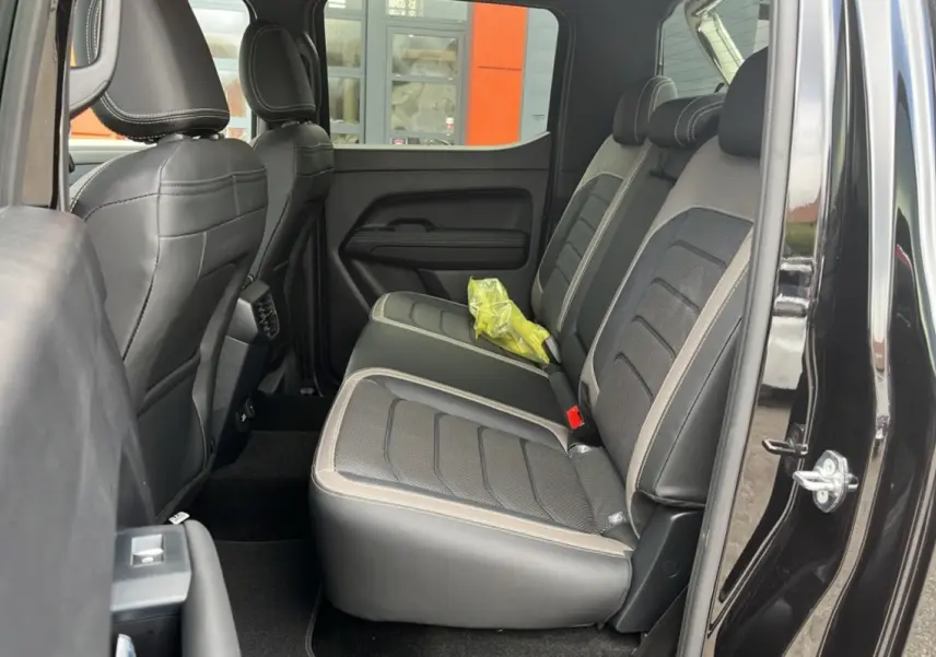 Vue intérieure côté droit sur les sièges arrière en cuir noir et gris du Volkswagen Amarok Simple Cabine 2025.
