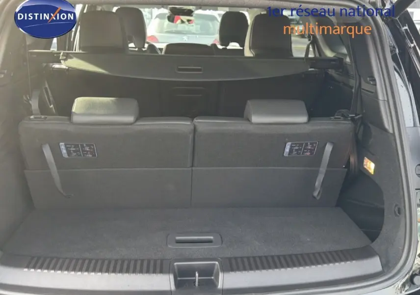 Coffre ouvert d'un Renault Espace 2025 noir étoile métal, montrant la banquette arrière et le cache-bagages.