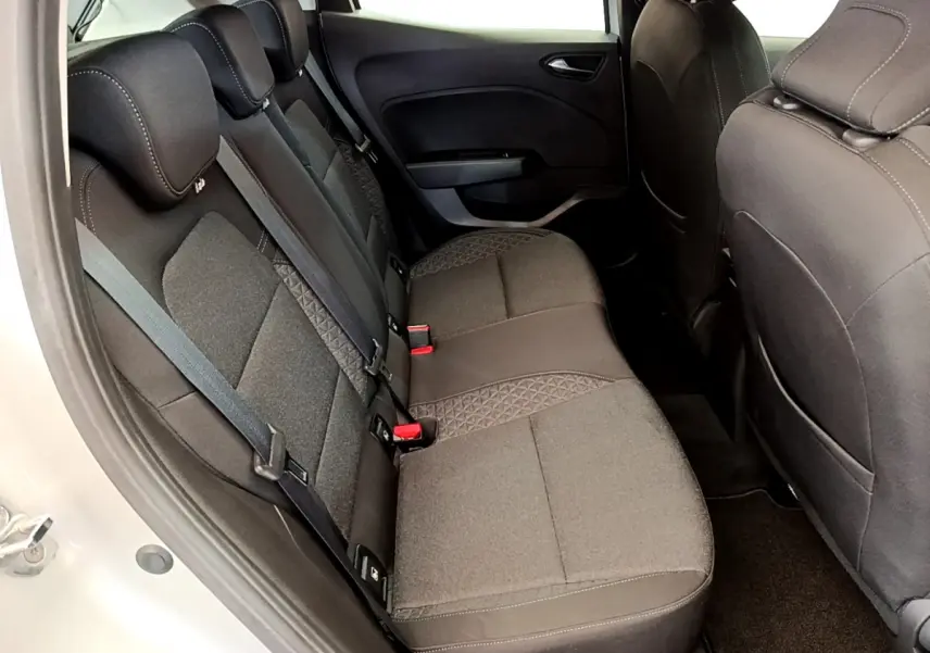 Vue intérieure côté arrière droit de la Renault Clio Business TCe 100 2020 avec sièges tissu gris foncé et ceintures visibles.