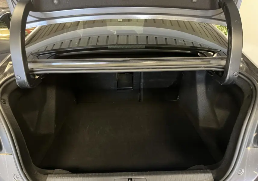 Coffre ouvert d'une Citroën C4 X 2024 gris, vue arrière montrant l'espace de chargement vide.
