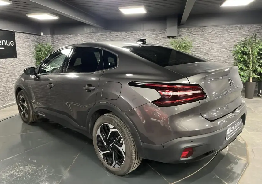 Vue 3/4 arrière droite d'une Citroën C4 X gris métallisé avec feux arrière LED et jantes alliage 18 pouces.